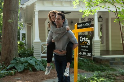 Alex (Rodrigo Santoro) carries preggo Holly (Jennifer Lopez) around the lawn of a Century 21 home.