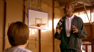 Bill Cobbs plays Arthur Chaney, 1950s New York Knick-turned janitor-turned grade school coach, seen here training the Timberwolves with an invisible basketball.