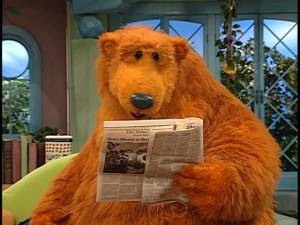 Bear looks for words in the newspaper.
