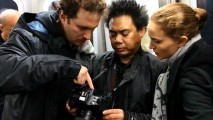 Mustachioed director Darren Aronofsky, cinematographer Matty Libatique, and Natalie Portman examine a digital camera as part of their New York City subway shoot.