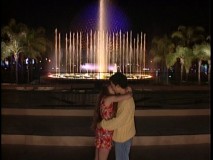 Topanga and Cory lock lips in front of EPCOT's Spaceship Earth and fountain.
