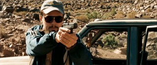 Leonardo DiCaprio takes on the Middle East with a baseball cap, sunglasses, facial hair, and a gun in "Body of Lies."