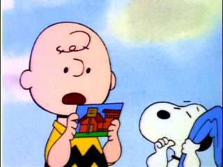 Charlie Brown reads a postcard from Linus to Snoopy, who has inherited the blue blanket and thumb-sucking in their friend's absence.