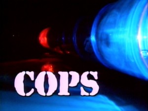The "COPS" title logo stands in its recognizable unchanged font, while a police car's red and blue lights flash and Inner Circle asks "Bad boys, bad boys, what you gonna do? What you gonna do when they come for you?"