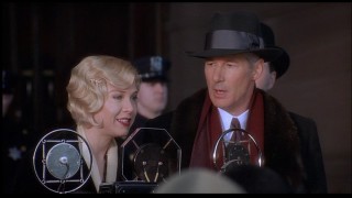 Richard Gere is perplexed that even the microphone can't strengthen his singing voice.
