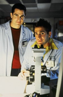 Former jock Nick Stokes (George Eads) and his lab-coated friend (Eric Szmanda) take a break from their microscopic work to smile for the camera.
