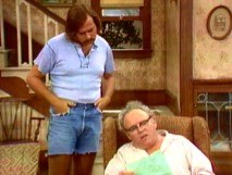 A heat wave causes Meathead to break out revealing jean short cut-offs as he reads a petition over Archie's shoulder.