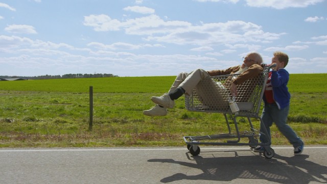 Eight-year-old Billy (Jackson Nicoll) pushes his drunken grandfather Irving Zisman (Johnny Knoxville) around in a shopping cart in "Jackass Presents: Bad Grandpa."
