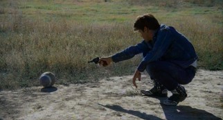 Kit shoots a football in the Badlands.