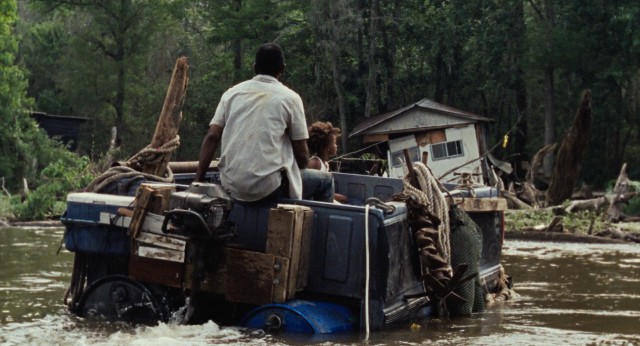 In a pick-up truck bed, father and daughter navigate the waters of their storm-ravaged community known as The Bathtub.