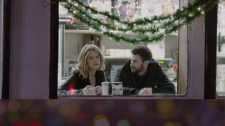 Nick and Brooke sit glumly under Christmas decorations in a coffee shop window on the Before We Go Blu-ray's menu.