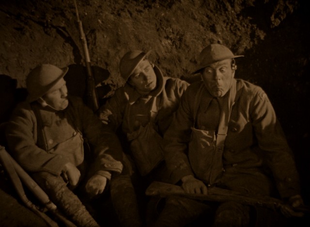 U.S. Army soldiers Bull (Tom O'Brien), Jim (John Gilbert), and Slim (Karl Dane) hold a spitting contest to determine who among them gets to leave the trench to check out the situation.