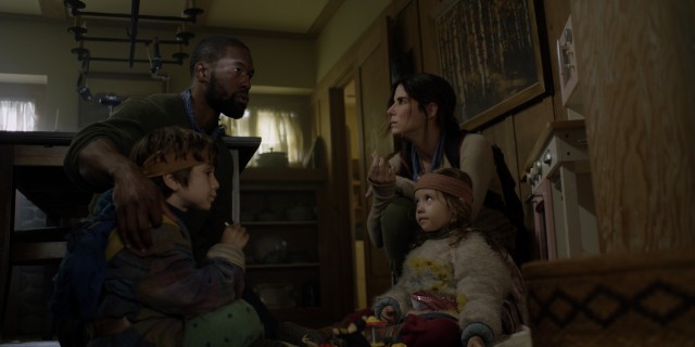 Tom (Trevante Rhodes), Malorie (Sandra Bullock), Boy (Julian Edwards), and Girl (Vivien Lyra Blair) are trying to stay alive in the apocalyptic thriller "Bird Box."