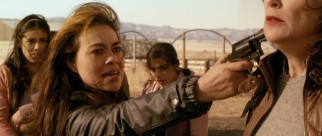 No-nonsense mule Juanita (Giovanna Zacarias) points a gun at the "Gringa."