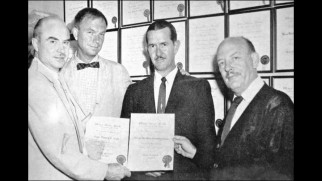A bunch of suited men (including Friz Freleng) proudly hold up documents in one of the image gallery's unclear behind-the-scenes photos.