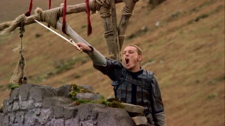 Arthur (Jamie Campbell Bower) shows his brave side by shouting, wielding a sword, and tying his hair into a tiny braid.