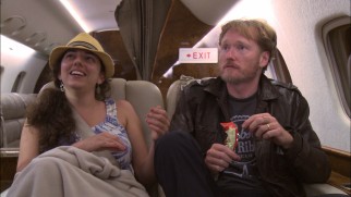 Conan cuts up on a post-Bonnarroo plane ride to his assistant Sona Movsesian's amusement.