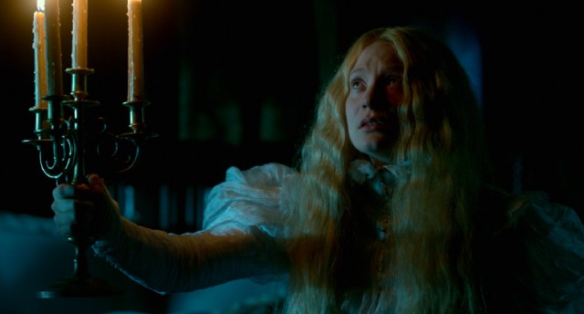 Mia Wasikowska strikes a classic gothic romance pose with candelabra in hand as "Crimson Peak" protagonist Edith Cushing.