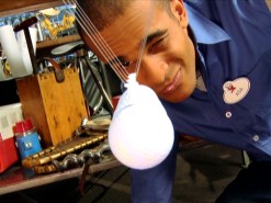 Asa Kalama squints a one-eyed look at the Newton's cradle he teaches how to build on "Energy."