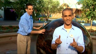 Asa Kalama explains why Newton's laws enable this 14-ton Kugel ball to move in the hands of enthusiastic intern Newton (Scott Nery).