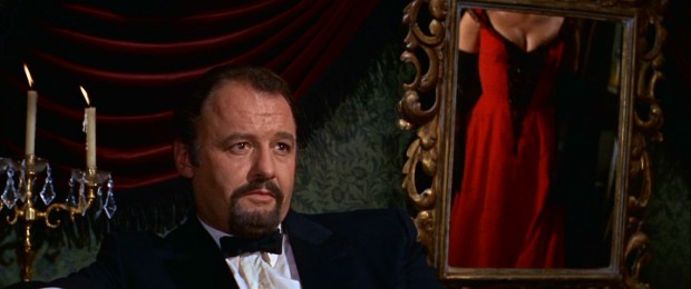 The complicated and none too charming Viktor Komarovsky (Rod Steiger) checks out the goods as his mistress's daughter Lara turns and models a red dress (seen in mirror).