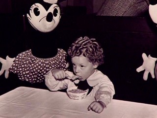 Young, curly-haired Donnie Dunagan eats from a Snow White and the Seven Dwarfs bowl between Mickey and Minnie Mouse in this photo from Bambi's 2005 DVD documentary.