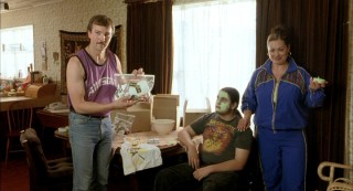 Craig Hall (left) plays Doug Davis, who isn't Uncle Rico, but may likely remind you of the nostalgic, mustachioed salesman. Here, Doug and wife Nancy (Rachel House) try to sell some discount makeup, with their teenaged son (Bernard Stewart) demonstrating the green face cream.