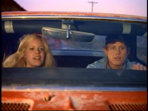 Darlene Kurtz (Christopher Norris) and Hoover Niebold (Ron Howard) are on the run in a stolen red race car in "Eat My Dust."