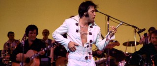 Elvis plays a little air guitar.