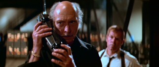 Best known for his villainous roles in spaghetti westerns, Lee Van Cleef plays Hauk, the US Police Force Commissioner who enlists Snake and checks in with him (in this case using a telephone that seems oversized for 1997).