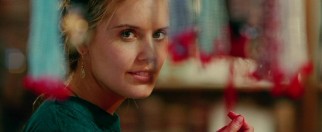 Bay (Maggie Grace) smiles at an Indian marketplace during one of Travis' colorful dreams.