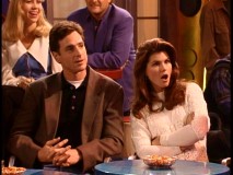 The hosts of "Wake Up, San Francisco" do not look pleased at being part of Joey's girlfriend's Smash Club comedy act.