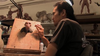A crew member works on a monster sculpture in "Don't Be Afraid of the Creatures."