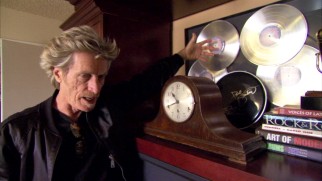 Journey's bass guitarist Ross Valory shows off his band's numerous platinum records.