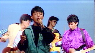 A young Arnel Pineda sings American songs with a colorfully dressed group of Filipino boys.
