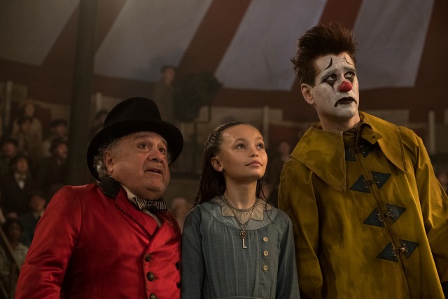 Max Medici (Danny DeVito), Milly (Nico Parker), and fireman clown Holt Farrier (Colin Farrell) watch as Dumbo takes flight.