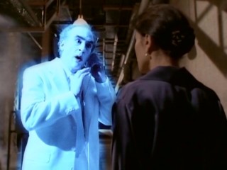 A glowing blue Jake Marley (Jeffrey DeMunn) gets directions on his 1990s-sized cellular telephone.