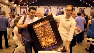 Fans at a convention show their love of Star Wars in an original trilogy poster they will get signed.