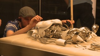 A crew member makes sure this robotic skeleton wreckage is just right in one of nine behind-the-scenes vignettes.