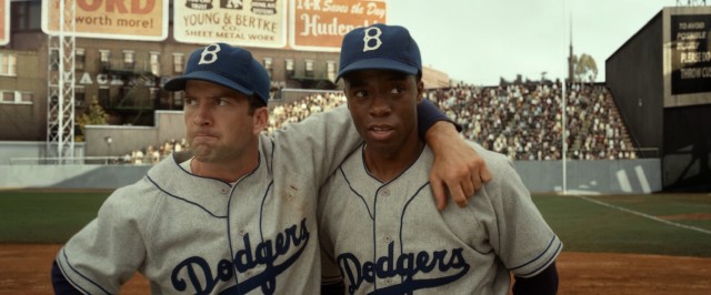 To audible disapproval, Hall of Fame-bound Dodgers shortstop Pee Wee Reese (Lucas Black) offers an arm around the shoulder and words of encouragement to his fellow infielder Jackie Robinson (Chadwick Boseman).