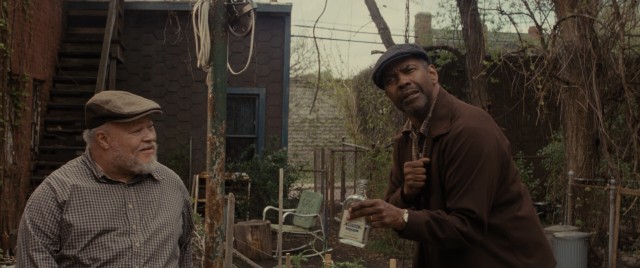 A somewhat inebriated Troy Maxson (Denzel Washington) animatedly tells the tale of how he told off Death, while his friend Jim Bono (Stephen McKinley Henderson) listens on.