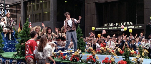 Ferris Bueller surprises his friends by leading a German-American parade float in a rousing lip-synching of Wayne Newton's "Danke Shoen."