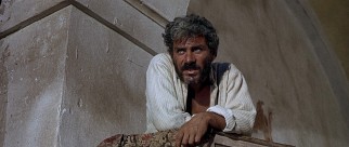 From a pulpit in an abandoned church, El Indio (Gian Maria Volont) preaches to his bandits about the El Paso bank they are to rob.