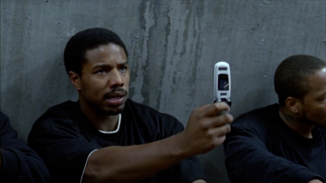 Oscar Grant (Michael B. Jordan) tries to use his cell phone while being detained on the Frutivale Station platform in the early morning hours of New Year's Day 2009.