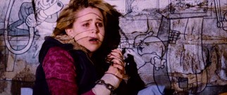 A chained-up Abby (Mae Whitman) has cartoons projected on her in the killer's dungeon of doom.