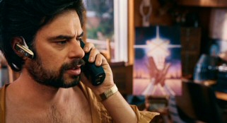 Taking a break from some shirtless cover painting, Bluetooth-wearing author Ronald Chevalier (Jemaine Clement) gets word that his publishers like his latest book (which he didn't actually write).