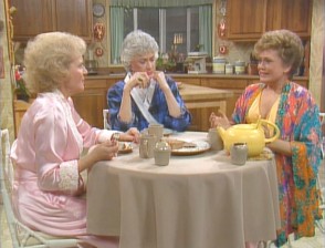 The girls gather around the table for some late night cheesecake.