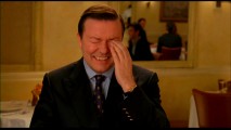 Ricky Gervais wipes away tears of laughter while corpsing in the Ghost Town bloopers reel. (Is he havin' a laugh?)