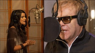 Nelly Furtado and Elton John duet from a distance in their brief, lazy "Crocodile Rock" music video.