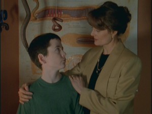 Todd (Noah Shebib) gets a pep talk from his mother (Caroline Yeager) about his worm obsession, which decorates the wall behind them.